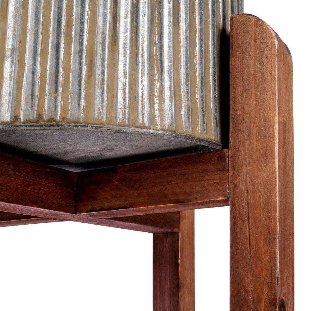 Silver colored fluted flower pot on a wooden stand