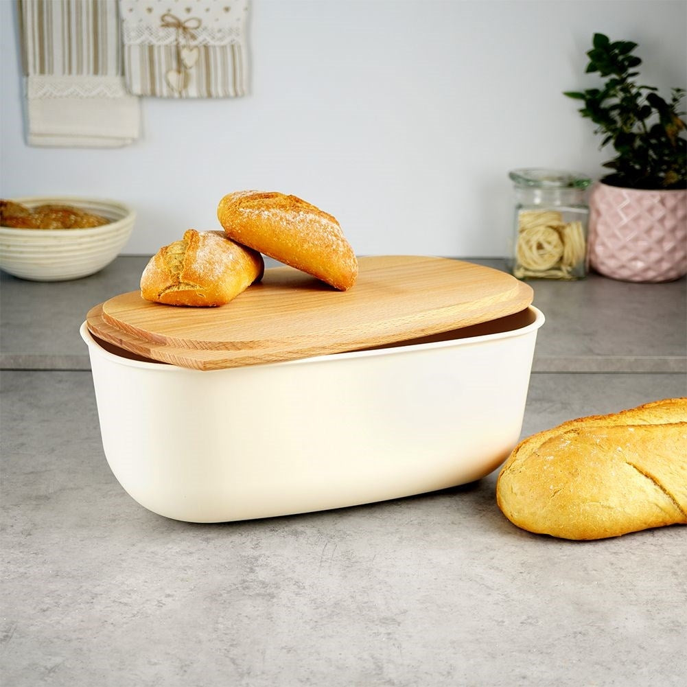 Spacious cream colored bread box with wooden cutting board
