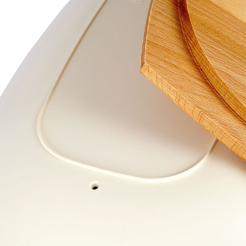 Spacious cream colored bread box with wooden cutting board