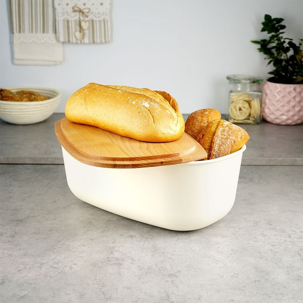 Spacious cream colored bread box with wooden cutting board