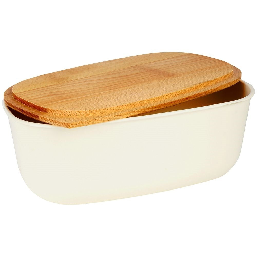 Spacious cream colored bread box with wooden cutting board