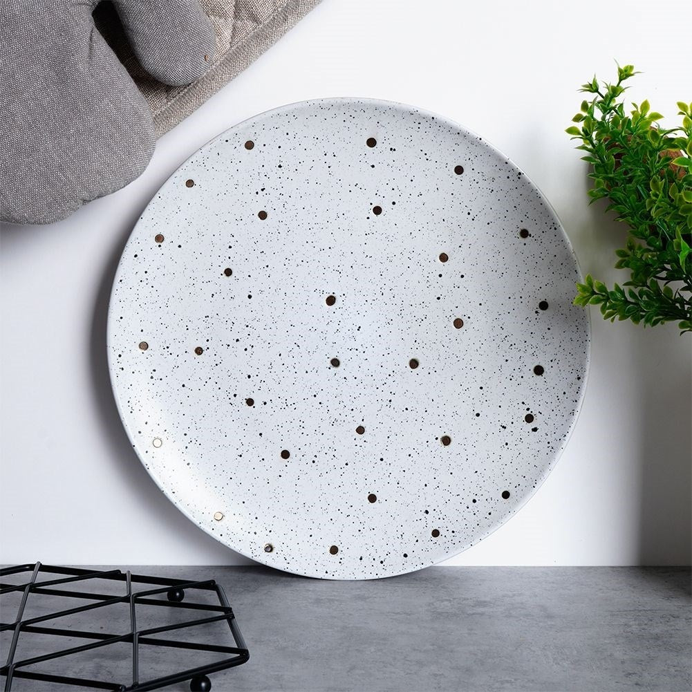 Splash-patterned matt white ceramic plate in black and gold