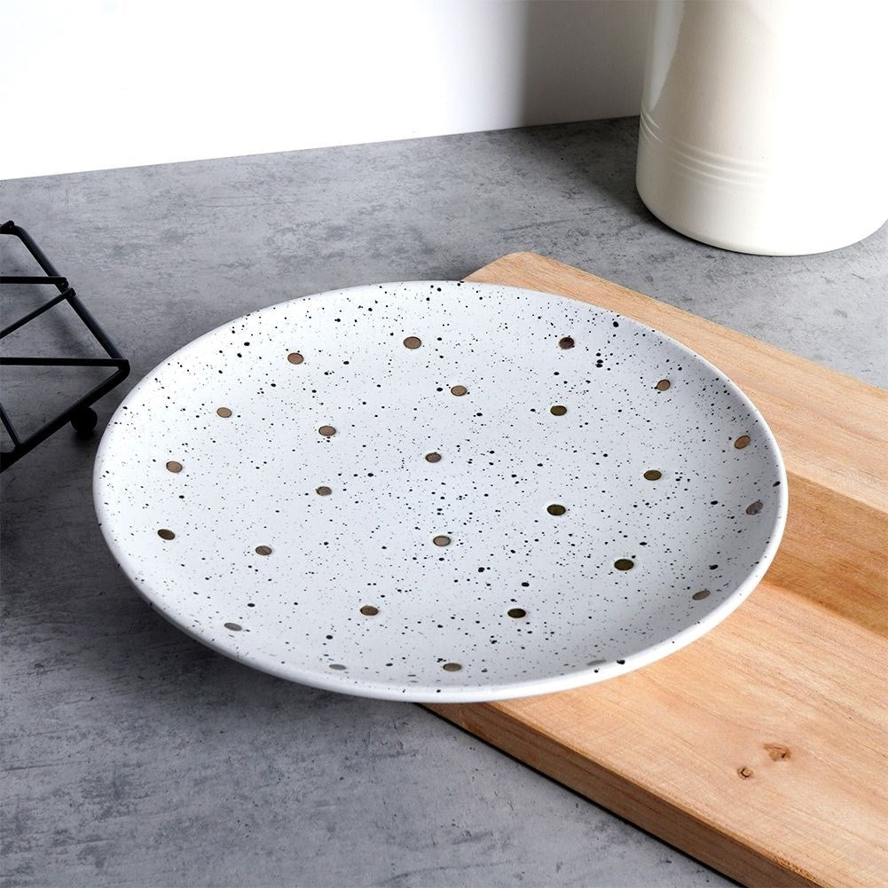 Splash-patterned matt white ceramic plate in black and gold