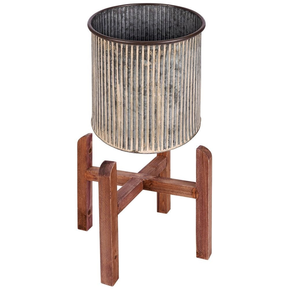 Steel flower pot with grooved surface on a wooden stand