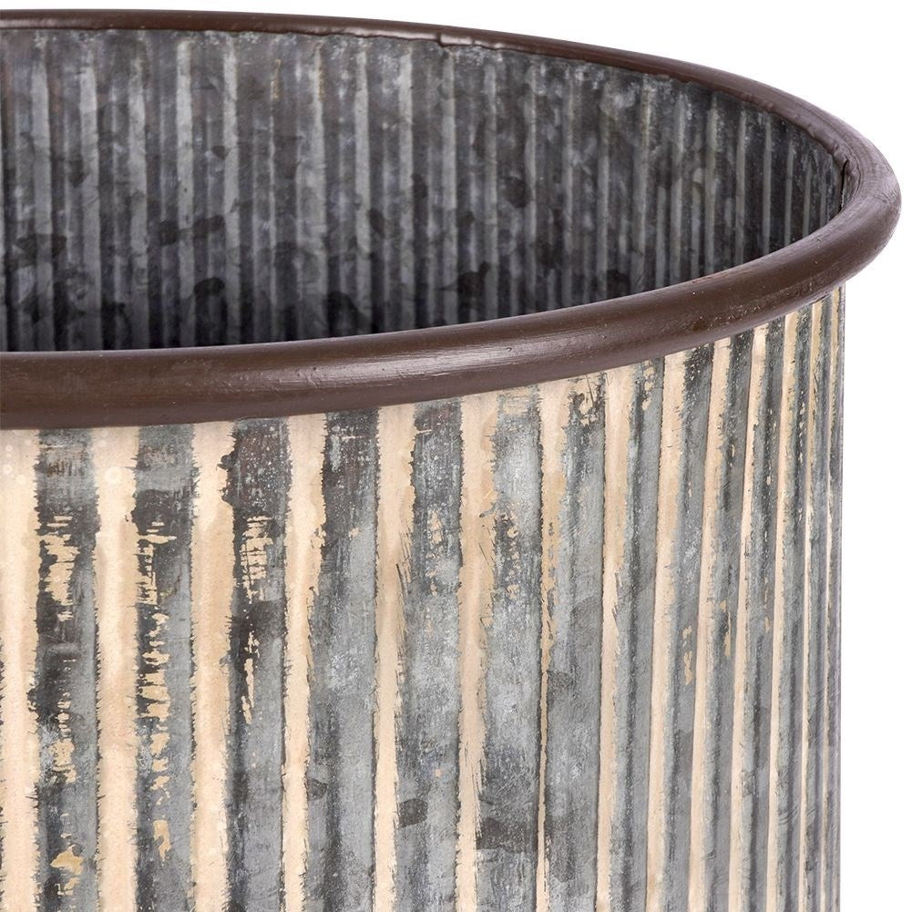 Steel flower pot with grooved surface on a wooden stand
