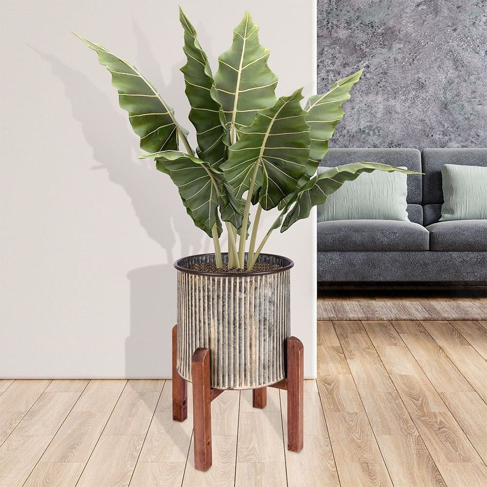 Steel flower pot with grooved surface on a wooden stand