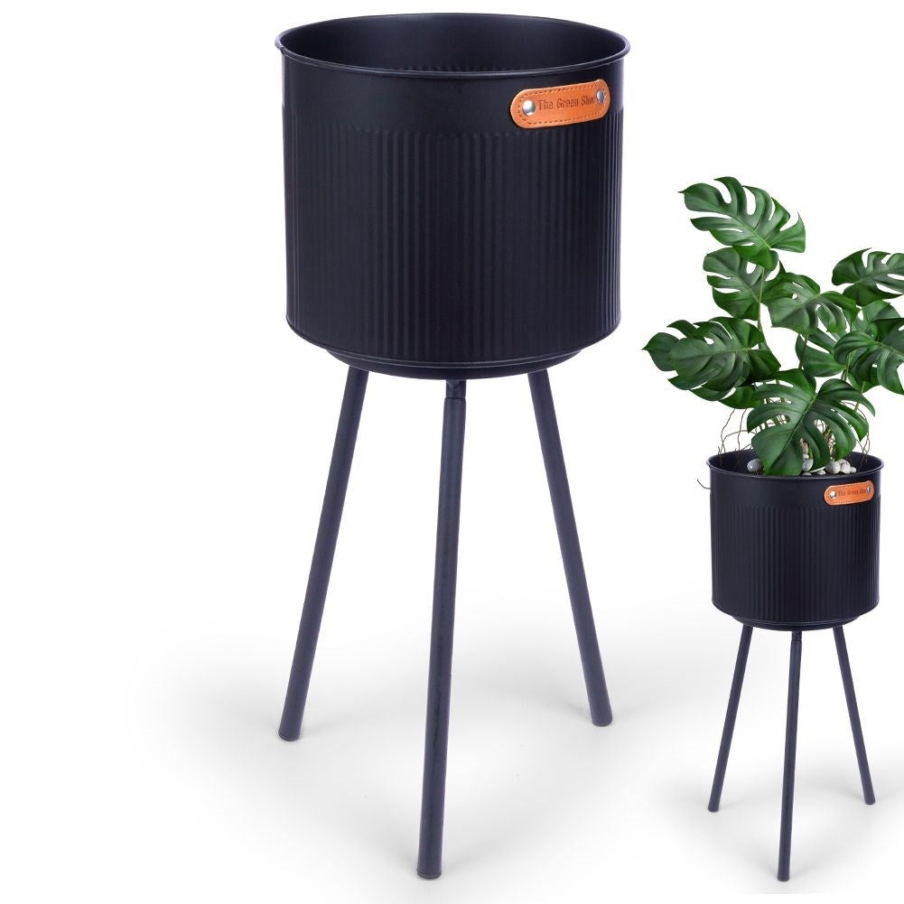 Stylish black metal pot with grooved surface and three legs