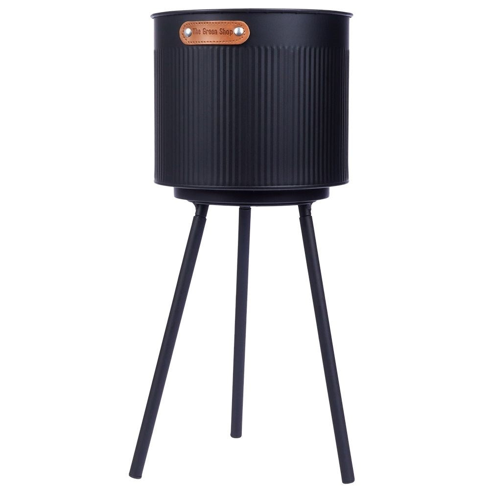 Stylish black metal pot with grooved surface and three legs