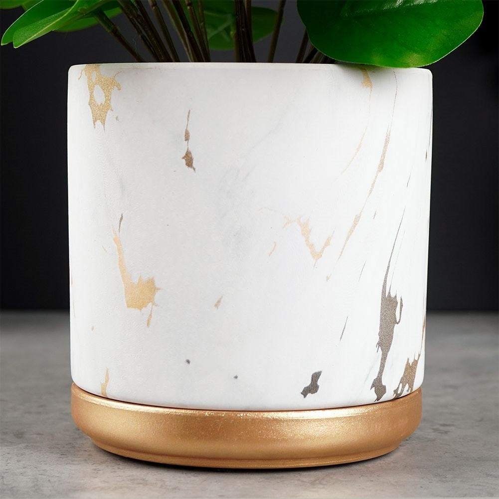 Stylish flower pot in a marble look with golden details