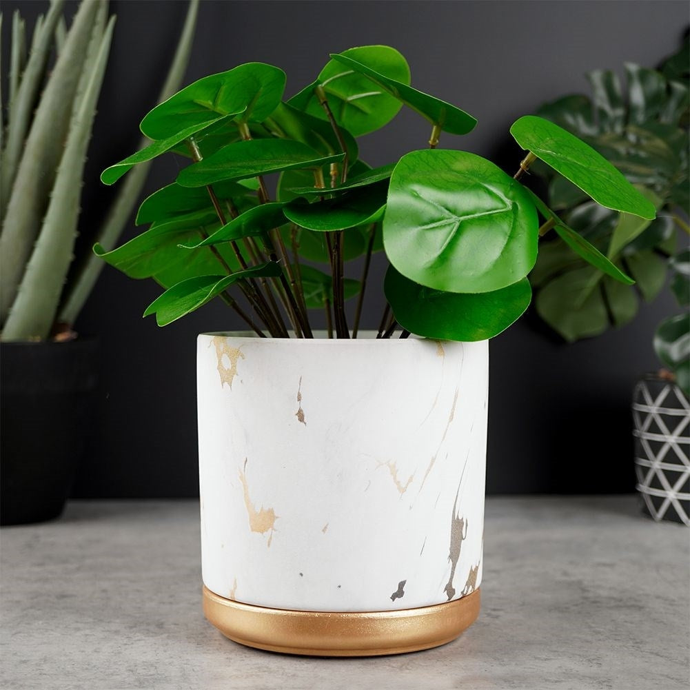 Stylish flower pot in a marble look with golden details