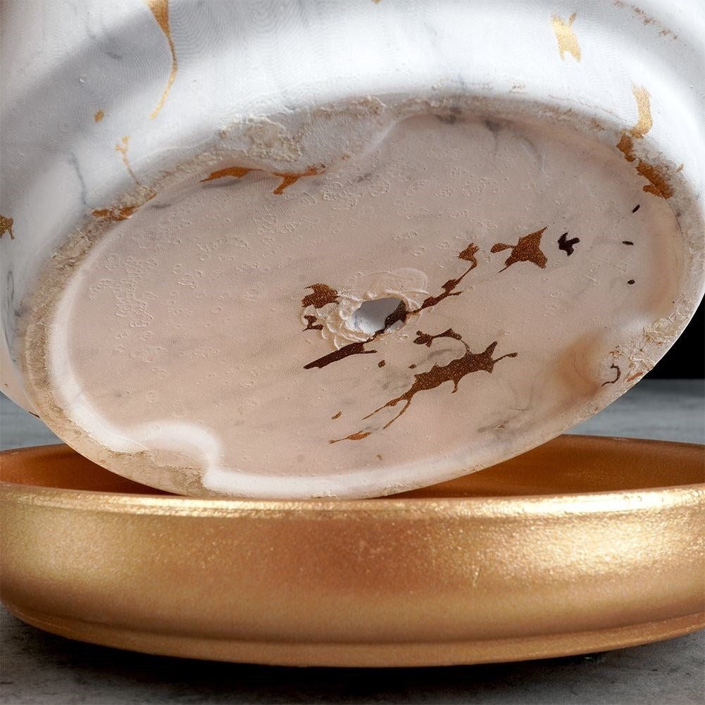 Stylish flower pot in a marble look with golden details