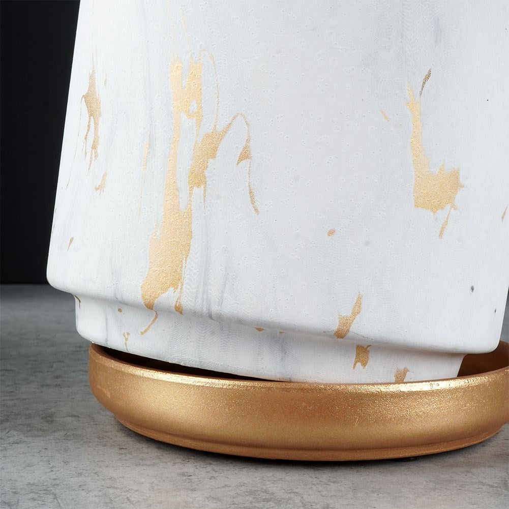 Stylish flower pot in a marble look with golden details