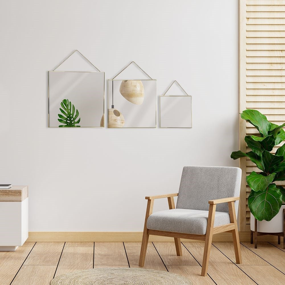 Stylish wall mirrors with golden metal frame and chain suspension