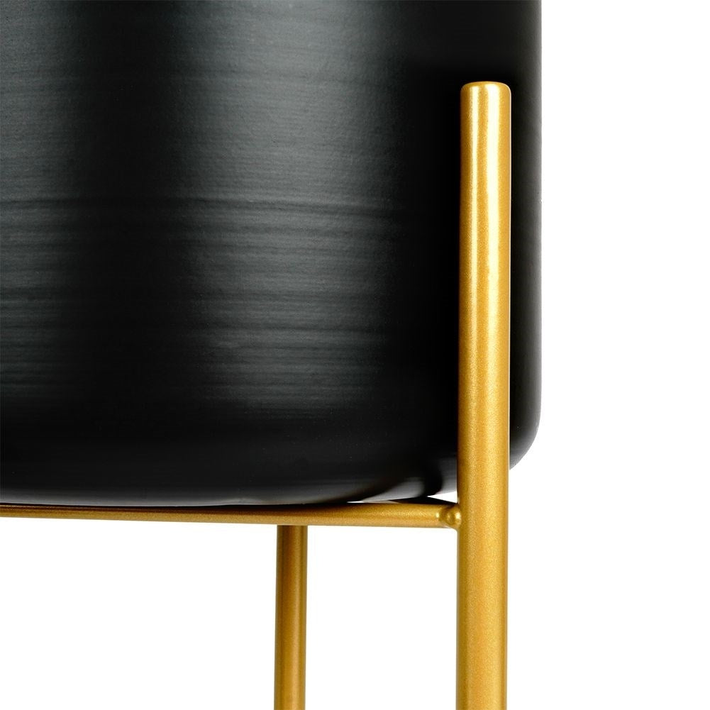 Three black flower pots on gold stand for elegant plant display