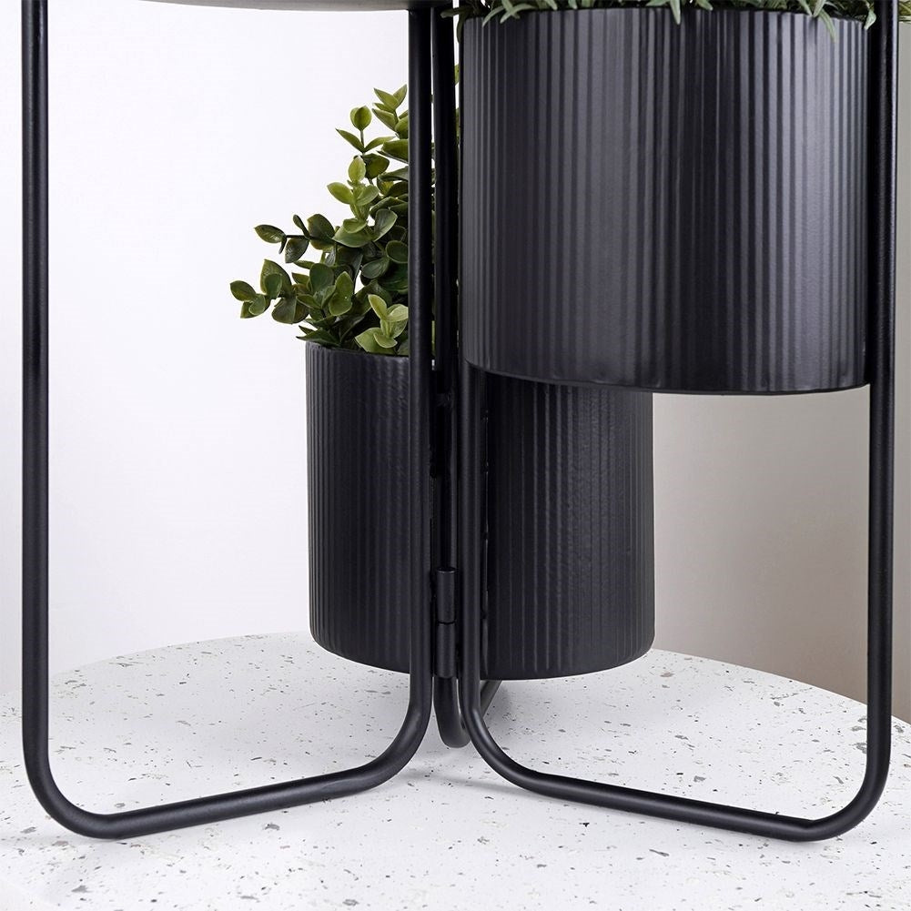 Three-legged flower stand in black metal for indoor use