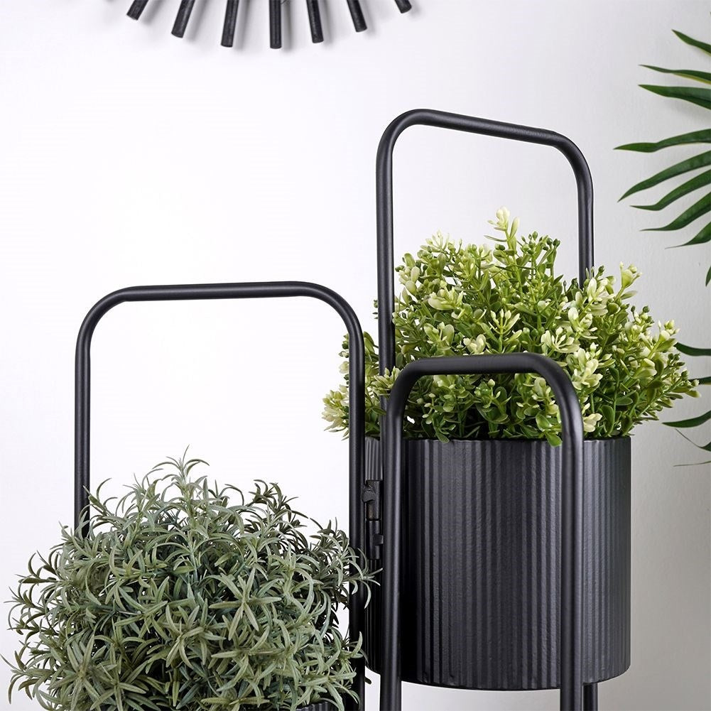 Three-legged flower stand in black metal for indoor use
