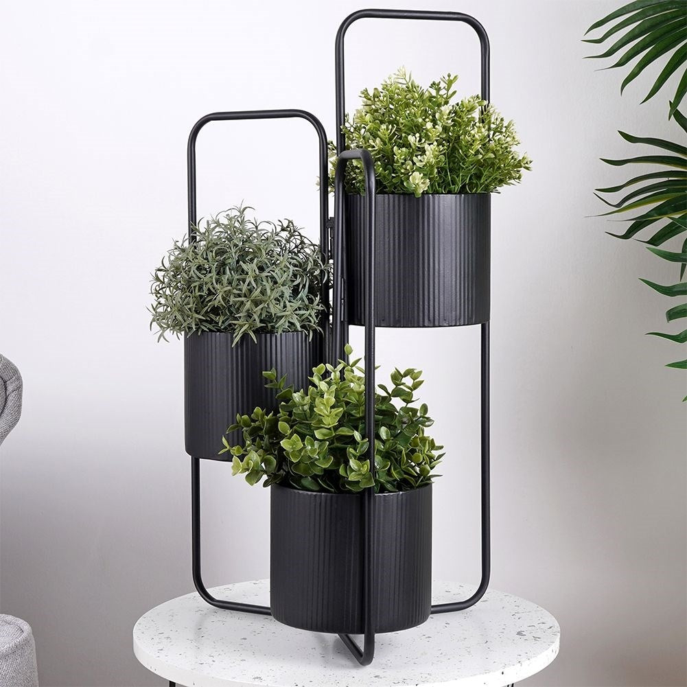 Three-legged flower stand in black metal for indoor use