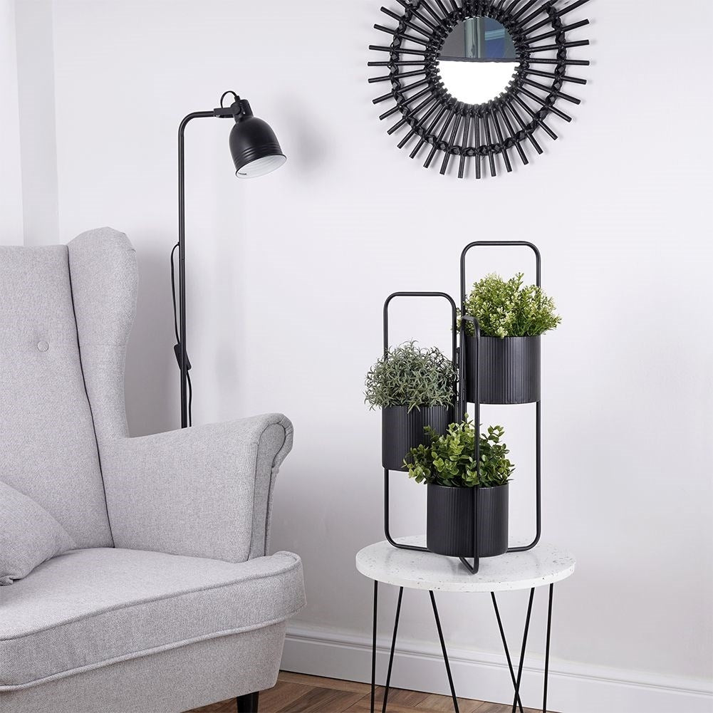 Three-legged flower stand in black metal for indoor use