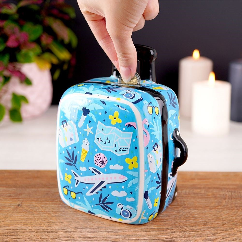 Travel bag-shaped piggy bank in blue ceramic with travel details