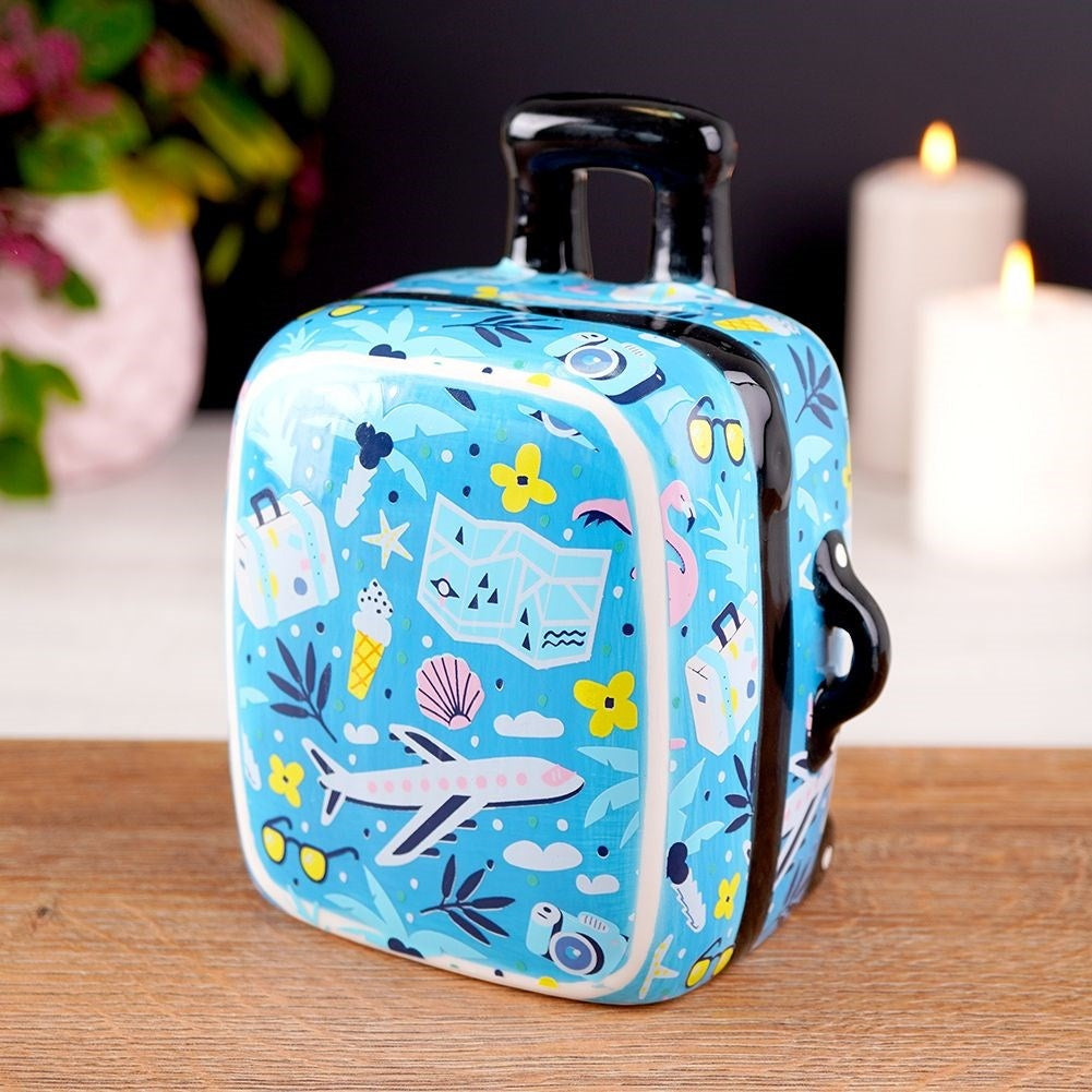 Travel bag-shaped piggy bank in blue ceramic with travel details
