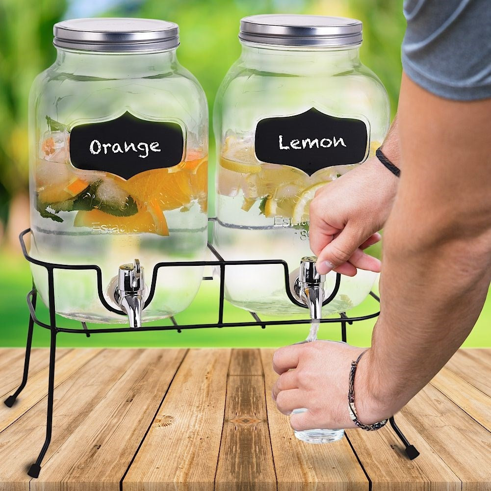 Two beverage containers with taps and metal lids on racks