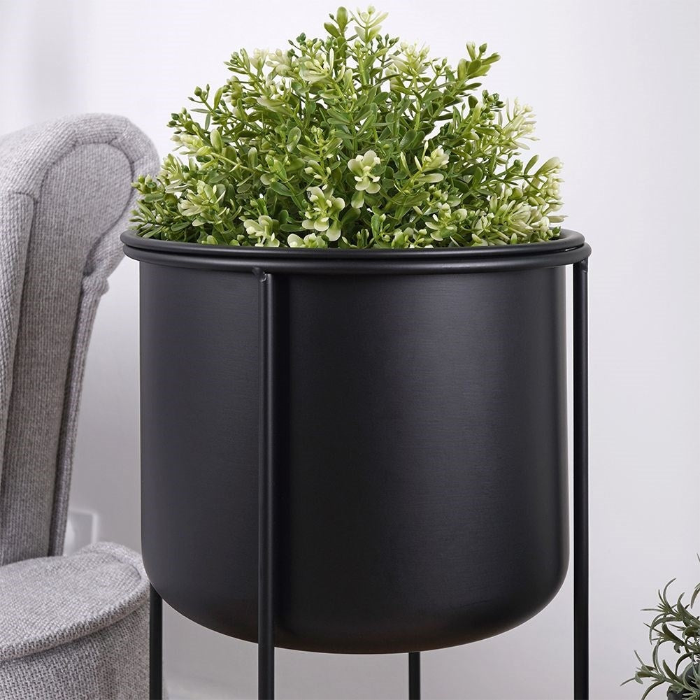 Two black metal pots with stands, different sizes