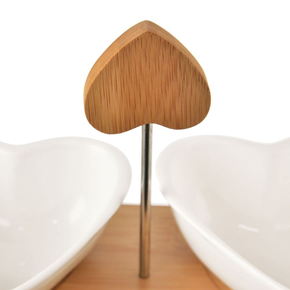 Two heart-shaped porcelain bowls on a bamboo tray for serving