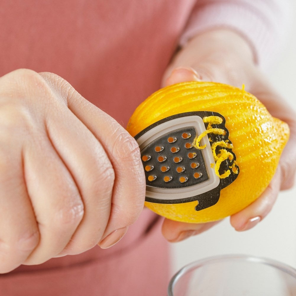 Versatile citrus press with scraper, grater and core remover