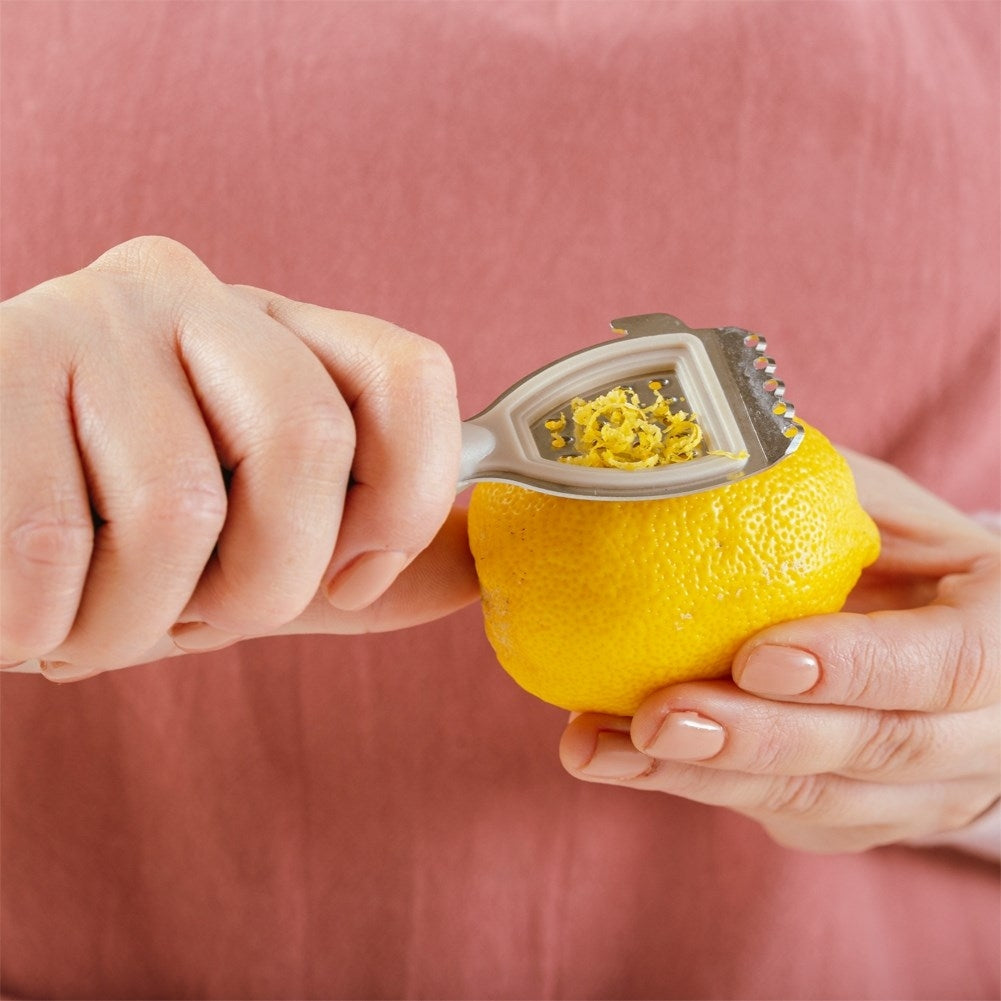 Versatile citrus press with scraper, grater and core remover
