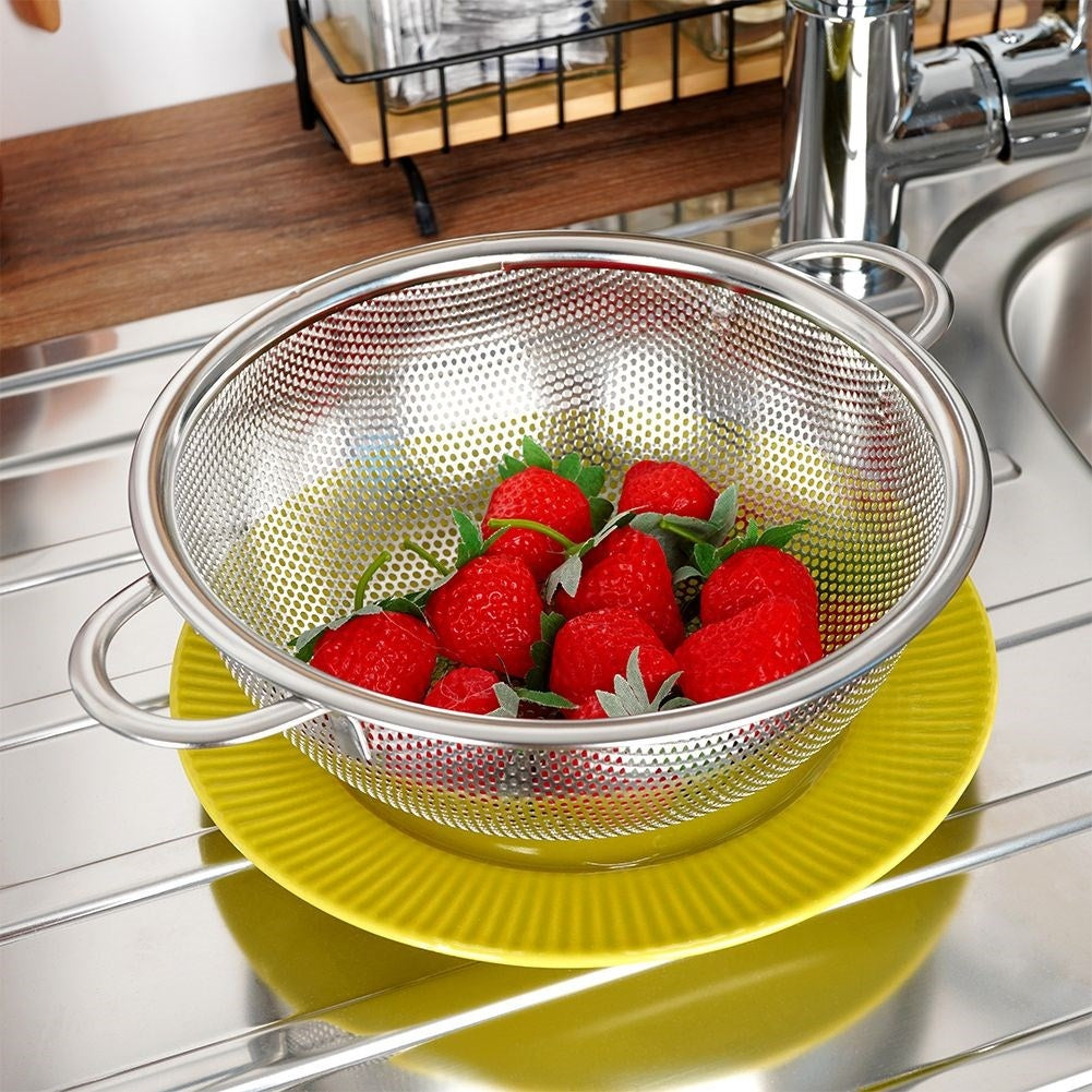 Versatile kitchen strainer in stainless steel with handle and legs