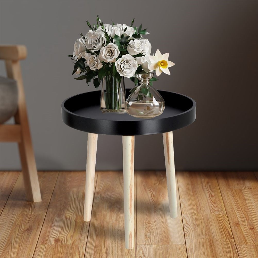 Versatile wooden coffee table with black table top and three legs