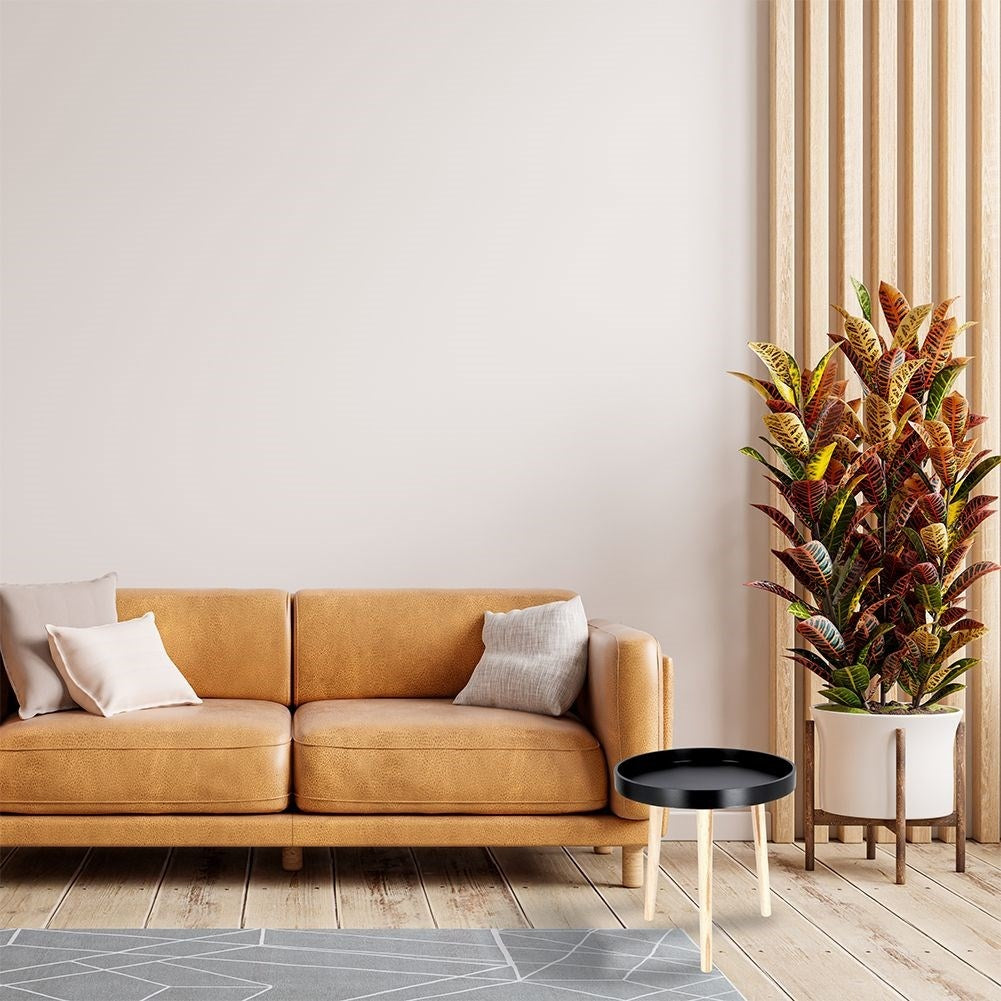 Versatile wooden coffee table with black table top and three legs