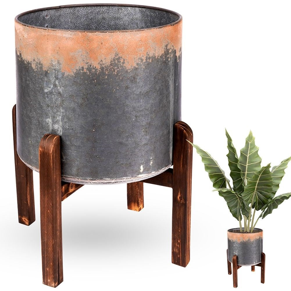 Vintage flower pot in steel with a rusty effect on a wooden stand