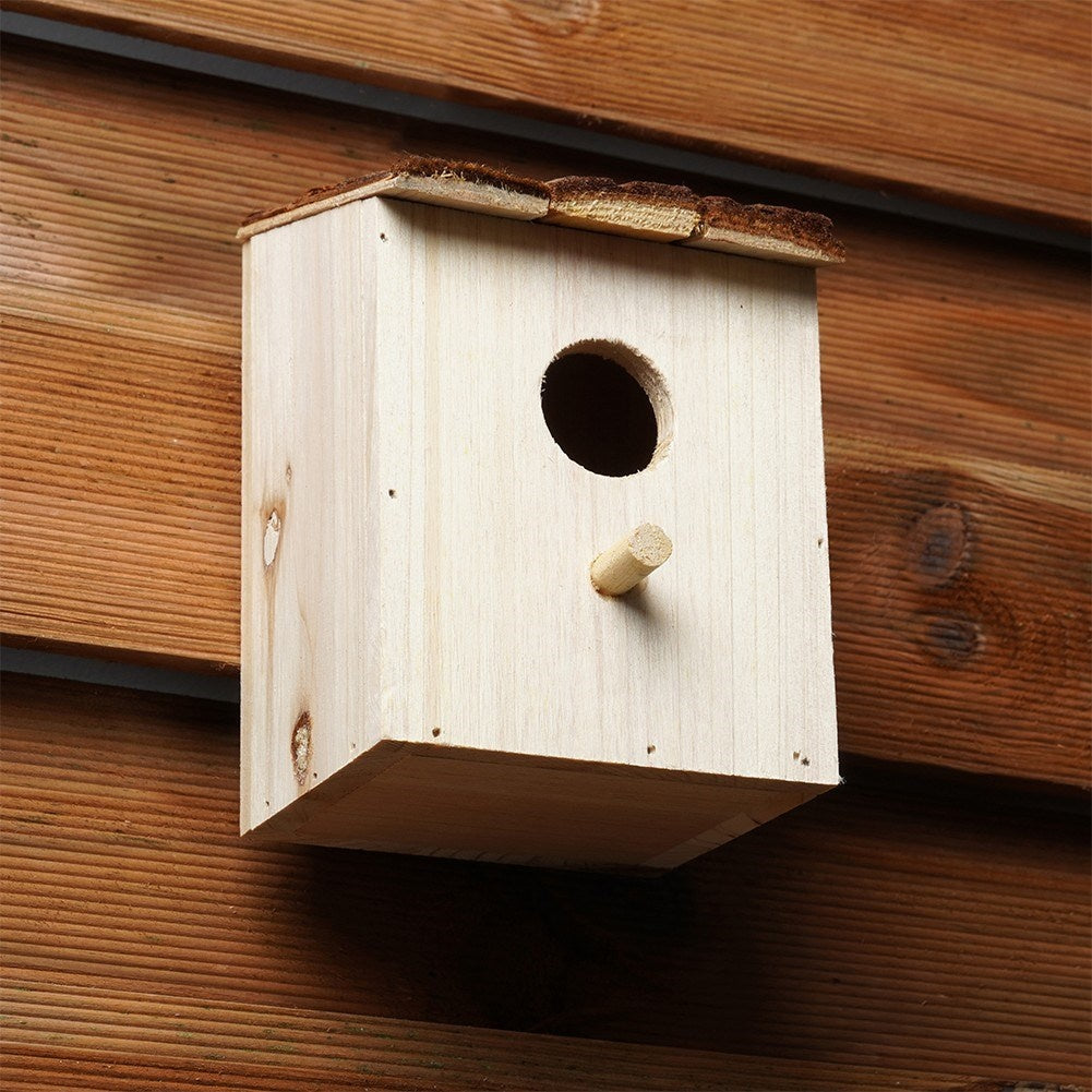 Wooden birdhouse with entrance opening for the garden
