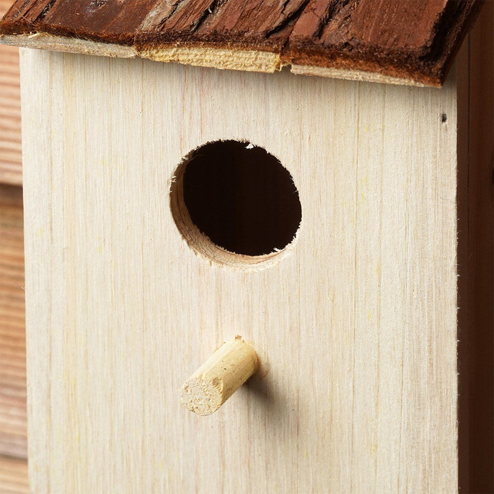 Wooden birdhouse with entrance opening for the garden