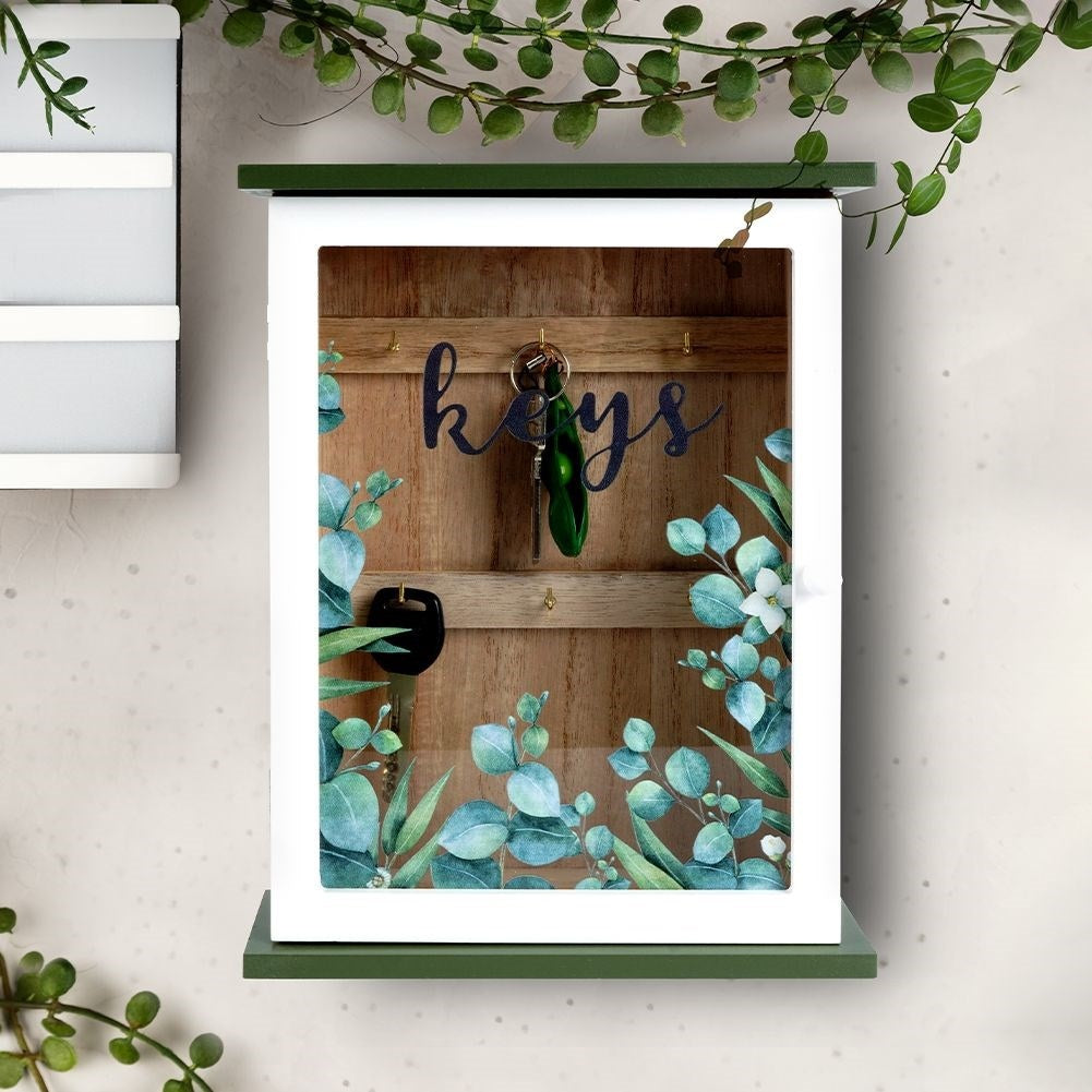 Wooden cabinet with glass doors and leaf motif for keys
