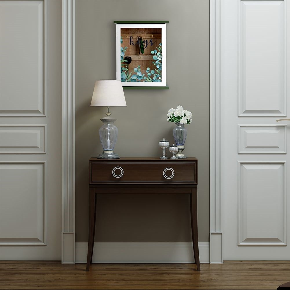 Wooden cabinet with glass doors and leaf motif for keys
